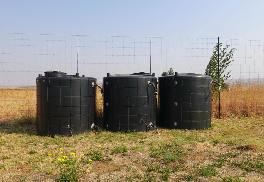Water storage tanks set on a fenced rural property in Williamson County